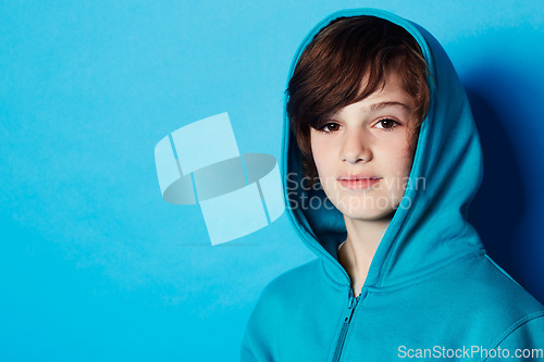 Image of Studio portrait, fashion and child in hoodie, trendy apparel or stylish clothes isolated on blue background. Mockup space, fashionable style and face of boy with warm winter fabric and casual outfit