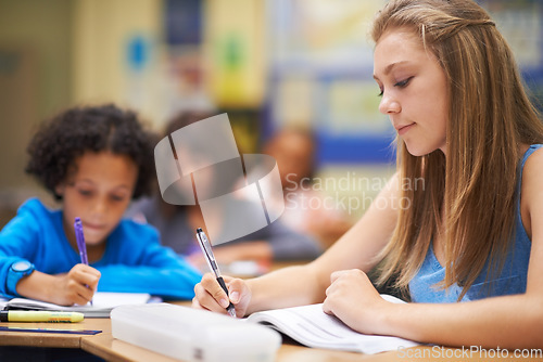 Image of Girl, classroom and writing in book for education, learning and notes for knowledge in high school. Female person, notebook and pride for assessment or test, studying lesson and exam at academy