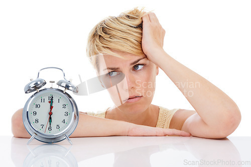 Image of Sad woman, alarm clock and headache from alert, wakeup or deadline on a white studio background. Frustrated female person or blonde looking at time in failure, loss or bored on table on mockup space