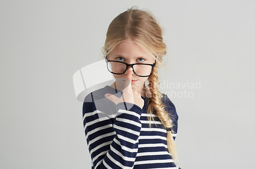 Image of Child, portrait and glasses with serious in mockup, thought and eyewear or nose in studio. Girl, face or geek with blonde hair in fashion with vision, contemplation or smart kid by white background