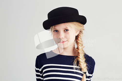 Image of Fashion, happy and portrait of child in a studio with casual, cool and stylish outfit and hat. Smile, youth and young girl kid with positive, good and confident attitude for style by white background