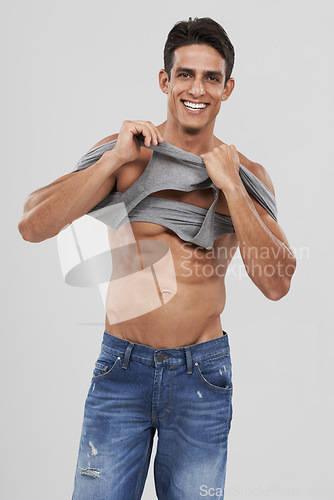 Image of Man, portrait and dressing or bodybuilder pride in studio, happy and fitness by white background. Male person, abs and strong core or muscular abdomen, confident and results or progress from exercise
