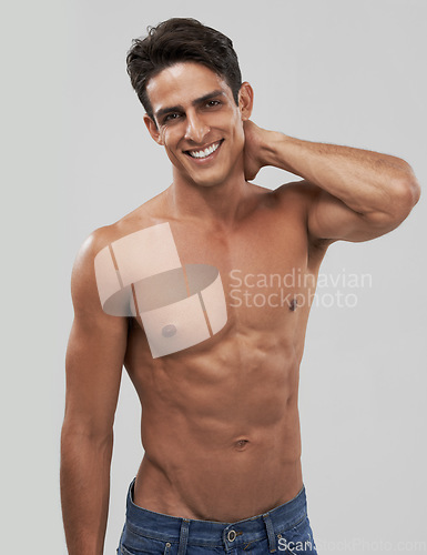 Image of Man, portrait and happy or shirtless bodybuilder in studio, smile and fitness by gray background. Male person, abs and strong core or muscular abdomen, confident and results or progress from exercise