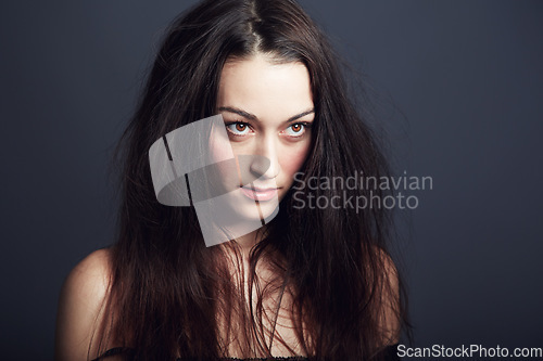 Image of Woman, hair and beauty with confidence and cosmetic care in studio, wellness and long hairstyle on dark background. Empowered, fierce and edgy with young model and texture, growth and salon treatment