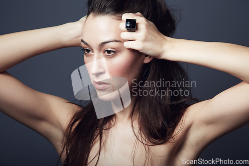 Image of Beauty, makeup and face of woman with hair in studio, hairstyle and shine on dark background. Portrait, cosmetic care glow on skin with dermatology, haircare and texture with growth and jewellery