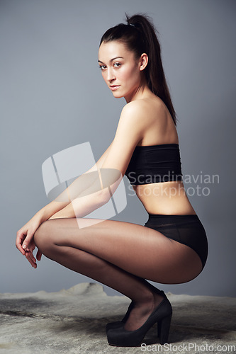 Image of Portrait, confidence and woman in underwear kneeling in studio isolated on a gray background. Serious slim model, beauty and natural body care, health and wellness of person in Brazil for fashion