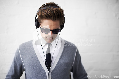 Image of Man, headphones and listening to song and relaxing to music by wall background, sound and peace. Male person, meditation and streaming radio or podcast, playlist and hearing audio and wellness