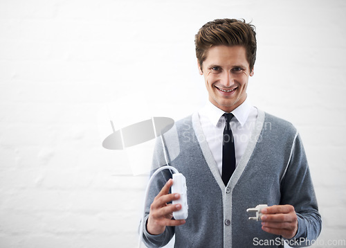 Image of Business man, portrait and plug with connection, cable or smile for electricity by wall background. Person, employee or entrepreneur with space, mockup and happy for power, energy or sustainability