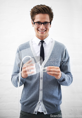 Image of Business man, portrait and plug with cable, connection or smile for electricity by wall background. Person, employee or entrepreneur for electronics, wire or happy for power, energy and link at job