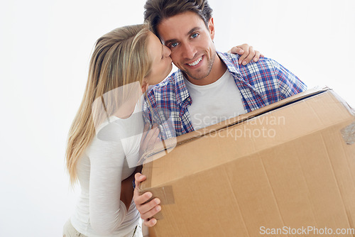 Image of Couple, boxes and happy with kiss for real estate, new home or property investment with romance or love. Moving, man and woman with smile, hug or embrace for fresh start, achievement and dream house