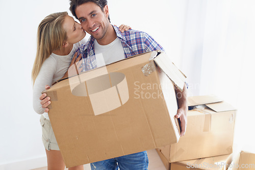 Image of Couple, boxes and smile with kiss for real estate, new home or property investment with romance or love. Moving, man and woman with happy, hug or embrace for fresh start, achievement and dream house