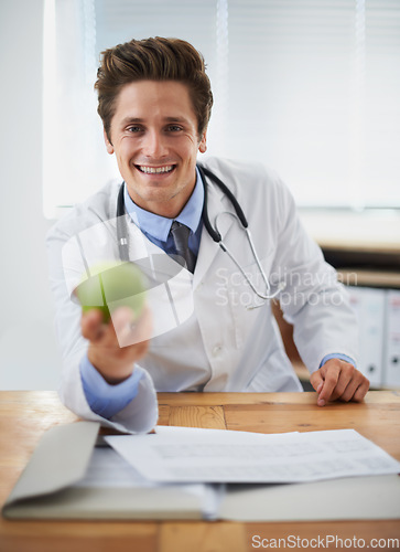 Image of Smile, apple and portrait of man doctor with stethoscope for positive, good and confident attitude. Happy, pride and young male healthcare worker with fruit in medical office of hospital or clinic.