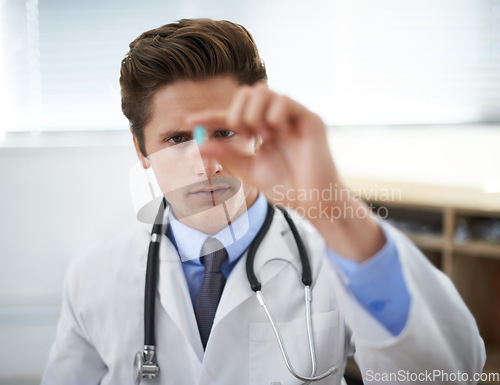 Image of Curious man, doctor and checking pill for healthcare, cure or drugs at hospital or office. Male person, surgeon or medical nurse looking at medication in research, study or examination at clinic