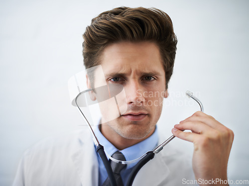 Image of Serious, stethoscope and portrait of doctor in his office for medical concern at hospital. Doubt, thinking or worried and handsome professional male healthcare worker working at medicare clinic.