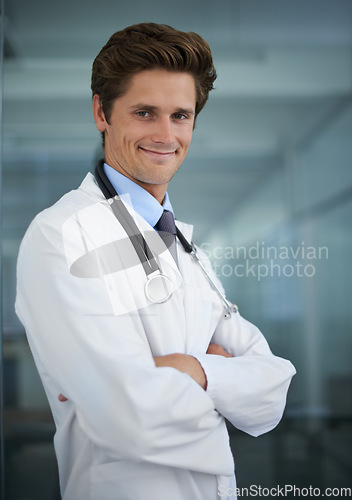 Image of Happy, crossed arms and portrait of man doctor with stethoscope for positive, good and confident attitude. Smile, pride and young male healthcare worker in medical office of hospital or clinic.
