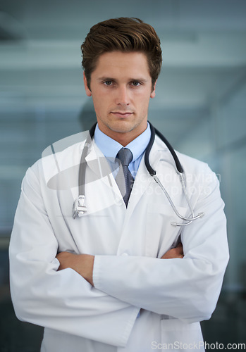 Image of Serious, crossed arms and portrait of man doctor with stethoscope for confident attitude. Career, pride and professional young male healthcare worker in medical office of hospital or clinic.