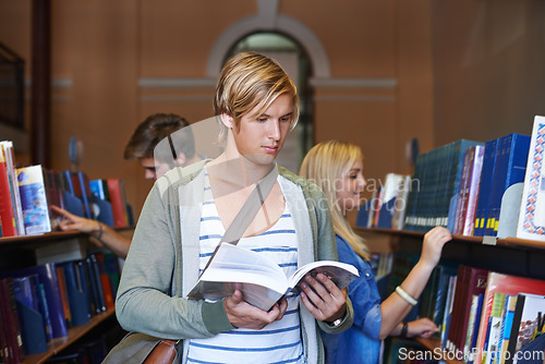 Image of Reading book, knowledge or man in library at university, college or school campus for future education. Bookshelf, focus or male student with scholarship studying research or learning information