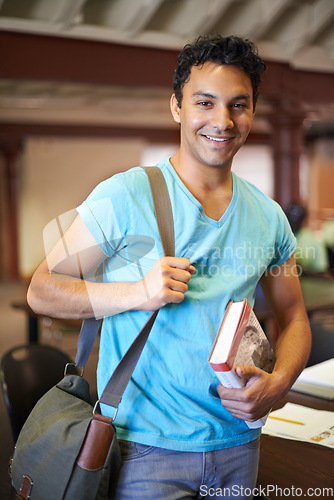 Image of Classroom, man or college student with book, portrait or studying for knowledge, development or academy. Person, bag and learning process with smile for pride, scholarship or education for assessment