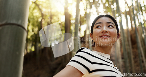 Image of Happy, bamboo and Japanese woman in forest for adventure on holiday, vacation and morning in woods. Travel, nature and person with natural plants in woods for explore, walking and freedom in Kyoto