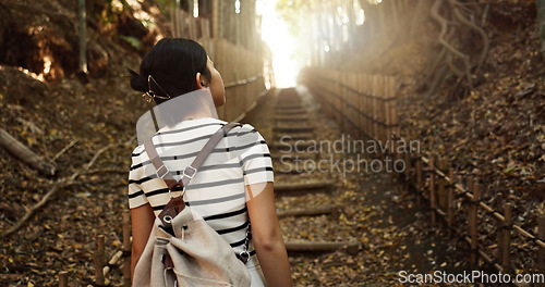 Image of Nature, travel and back of Japanese woman in park for adventure on holiday, vacation and morning in woods. Relax, happy and person in forest, path and trail to explore, walking and freedom in Kyoto