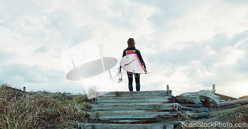 Image of Surfing, beach and woman on stairs with surfboard for water sports, fitness and freedom by ocean. Nature, travel and back of person for wellness on holiday, vacation and adventure by tropical sea