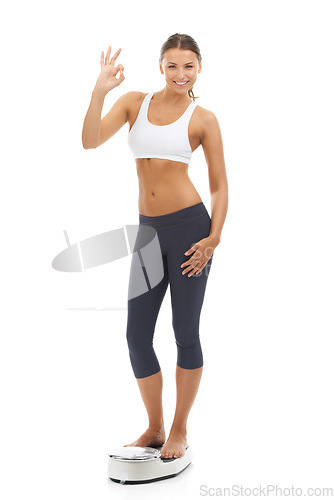 Image of Studio portrait, scale or happy woman with okay gesture for weight loss progress, healthy lifestyle or body transformation goals. Well done, model or ok icon for good diet results on white background