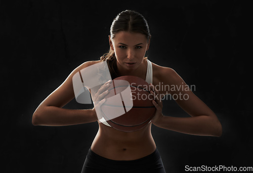 Image of Serious, woman and portrait with basketball for sports and game in black background or studio. Fitness, challenge and intense athlete on the court, competition or training in workout and exercise