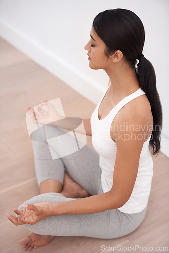 Image of Woman, meditation and calm in a home with mockup space and chakra for balance and mindfulness. Morning, wellness and zen in house on floor to relax for spiritual practice and peace in lotus position