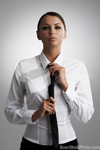 Image of Portrait, business and woman adjust tie in studio isolated on a gray background. Face, confidence and professional straighten clothes, shirt for style and beauty of serious fashion model in Brazil