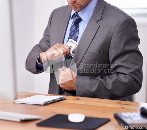 Image of Business man, money laundering and pocket for corporate crime, stealing or fraud in accounting at his office desk. Person or criminal hands hiding cash for investment secret, bribery and corruption