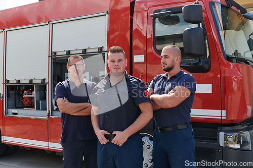 Image of A skilled and dedicated professional firefighting team proudly poses in front of their state of the art firetruck, showcasing their modern equipment and commitment to ensuring public safety.