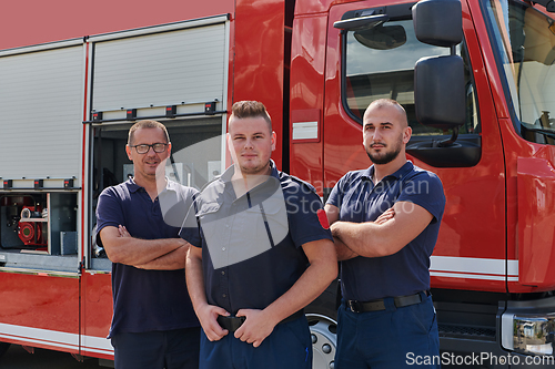 Image of A skilled and dedicated professional firefighting team proudly poses in front of their state of the art firetruck, showcasing their modern equipment and commitment to ensuring public safety.