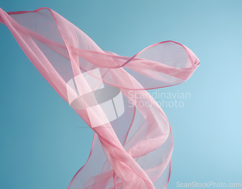 Image of Flying pink fabric wave on blue sky background and illuminated b