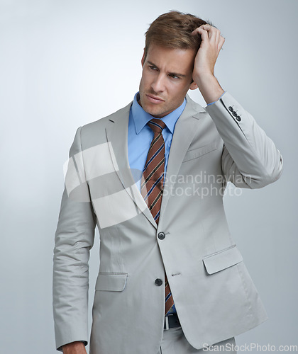 Image of Confused, thinking and young businessman in a studio with doubt, unsure or decision facial expression. Choice, uncertain and professional male person in a suit with question face by gray background.