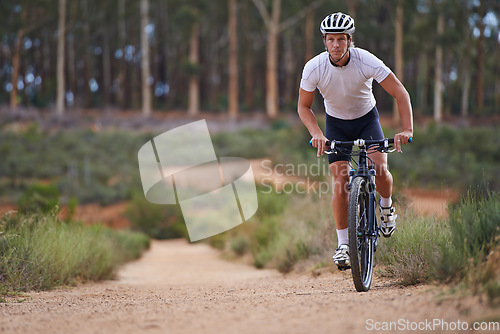 Image of Man, mountain bike and cycling in forest for adventure or extreme sport, exercise or athlete. Male person, transportation and off road terrain for countryside training or health, workout or challenge