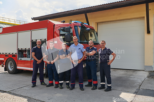 Image of A skilled and dedicated professional firefighting team proudly poses in front of their state of the art firetruck, showcasing their modern equipment and commitment to ensuring public safety.