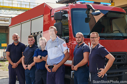 Image of A skilled and dedicated professional firefighting team proudly poses in front of their state of the art firetruck, showcasing their modern equipment and commitment to ensuring public safety.