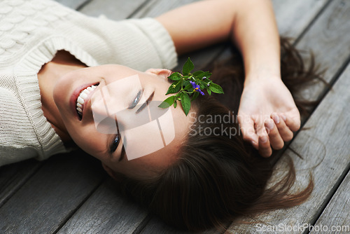 Image of Woman lying on her porch, relax and summer with smile, happiness and chilling on a weekend break. Person, outdoor and girl with joy, cheerful and plant in her hair, holiday and floral with vacation