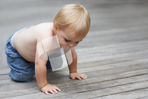 Image of Toddler, playing on floor outdoor for development with relax, curiosity and early childhood in backyard of home. Baby, child and crawling on ground for wellness, milestone or exploring with innocence