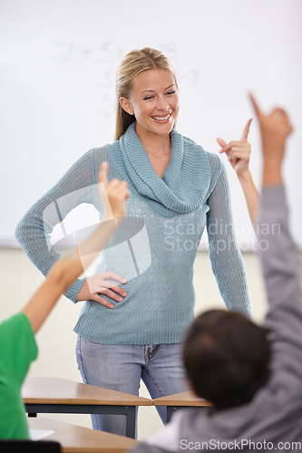 Image of Question, woman and teacher with students, children and knowledge in a classroom. School, employee and kids with hands in the air, answer and child development with educator, learning and happiness