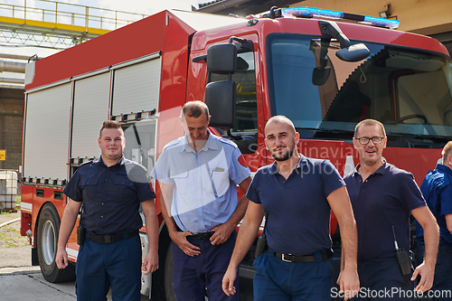 Image of A skilled and dedicated professional firefighting team proudly poses in front of their state of the art firetruck, showcasing their modern equipment and commitment to ensuring public safety.