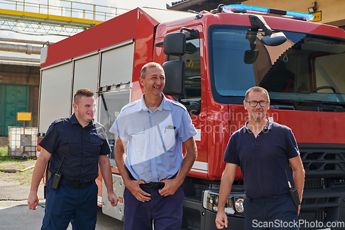 Image of A skilled and dedicated professional firefighting team proudly poses in front of their state of the art firetruck, showcasing their modern equipment and commitment to ensuring public safety.