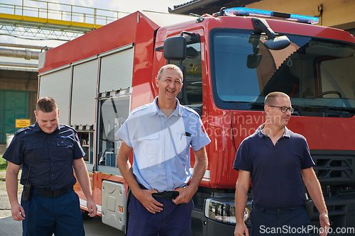 Image of A skilled and dedicated professional firefighting team proudly poses in front of their state of the art firetruck, showcasing their modern equipment and commitment to ensuring public safety.