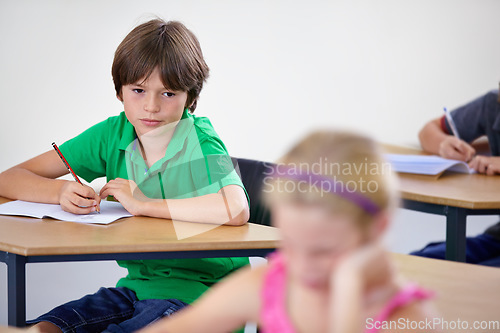 Image of Children, education and boy writing a test, knowledge and learning with an exam, information and school. Kids, classroom and child development with a notebook, studying and desk with girl or creative