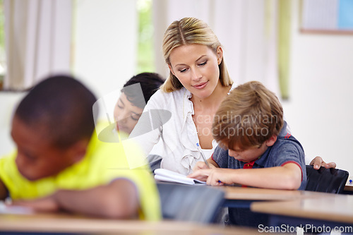 Image of Teacher, kid or writing in classroom for learning, education and helping for language development or support. Woman teaching, assessment or child student with knowledge or notebook at middle school