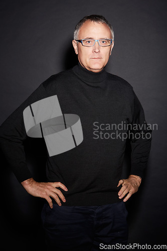 Image of Portrait of mature man in studio with confidence, glasses and dark fashion style in retirement. Pride, relax and senior person isolated on black background with expert knowledge, mystery and wisdom.