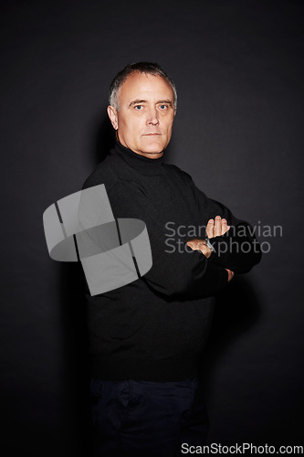 Image of Serious portrait of mature man in studio with arms crossed, confidence and dark fashion style. Pride, relax and senior person isolated on black background with expert knowledge, mystery and wisdom.