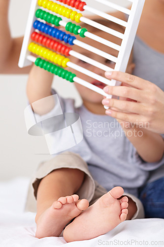Image of Abacus, math and baby with mother playing, learning and teaching for child development on bed. Bonding, toy and closeup of mom with kid, infant or toddler with counting together in bedroom at home.