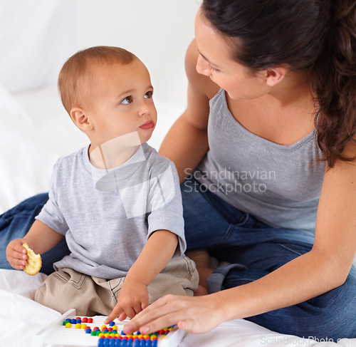 Image of Abacus, bonding and baby with mother playing, learning and teaching for child development on bed. Math, toy and closeup of mom helping kid, infant or toddler with counting in bedroom at home.