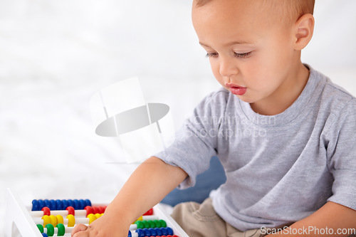 Image of Abacus, math and boy baby learning, playing and teaching for child development on bed. Preschool, youth and closeup of kid, infant or toddler with counting for toy in bedroom or nursery at home.